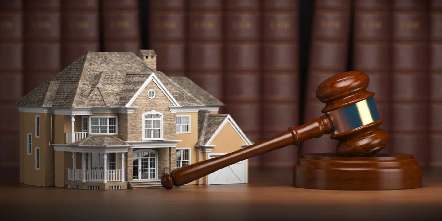 Model house and a gavel in front of law books