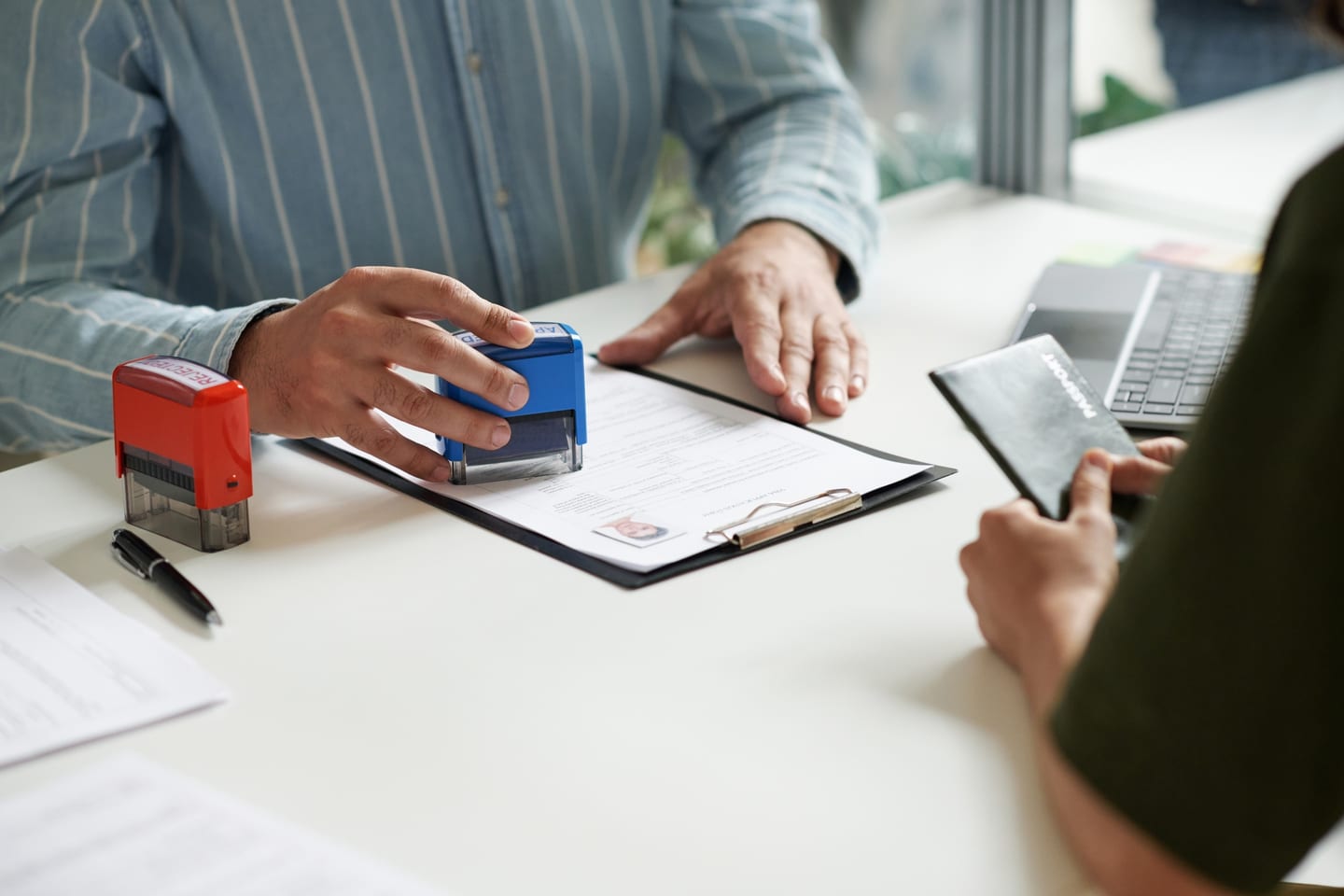 Manager handing an approved visa to a professional