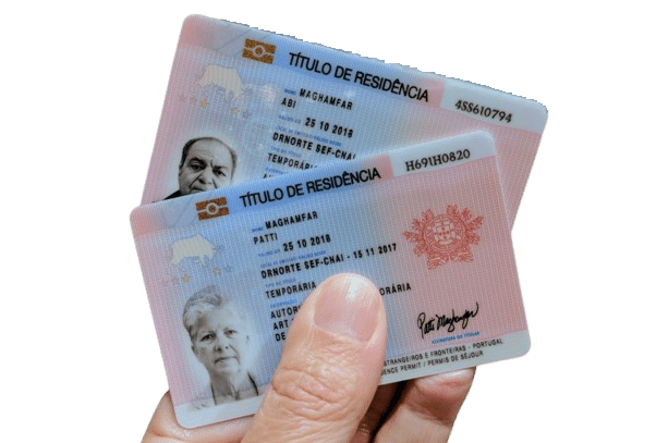 Portuguese residence permit card held over travel documents