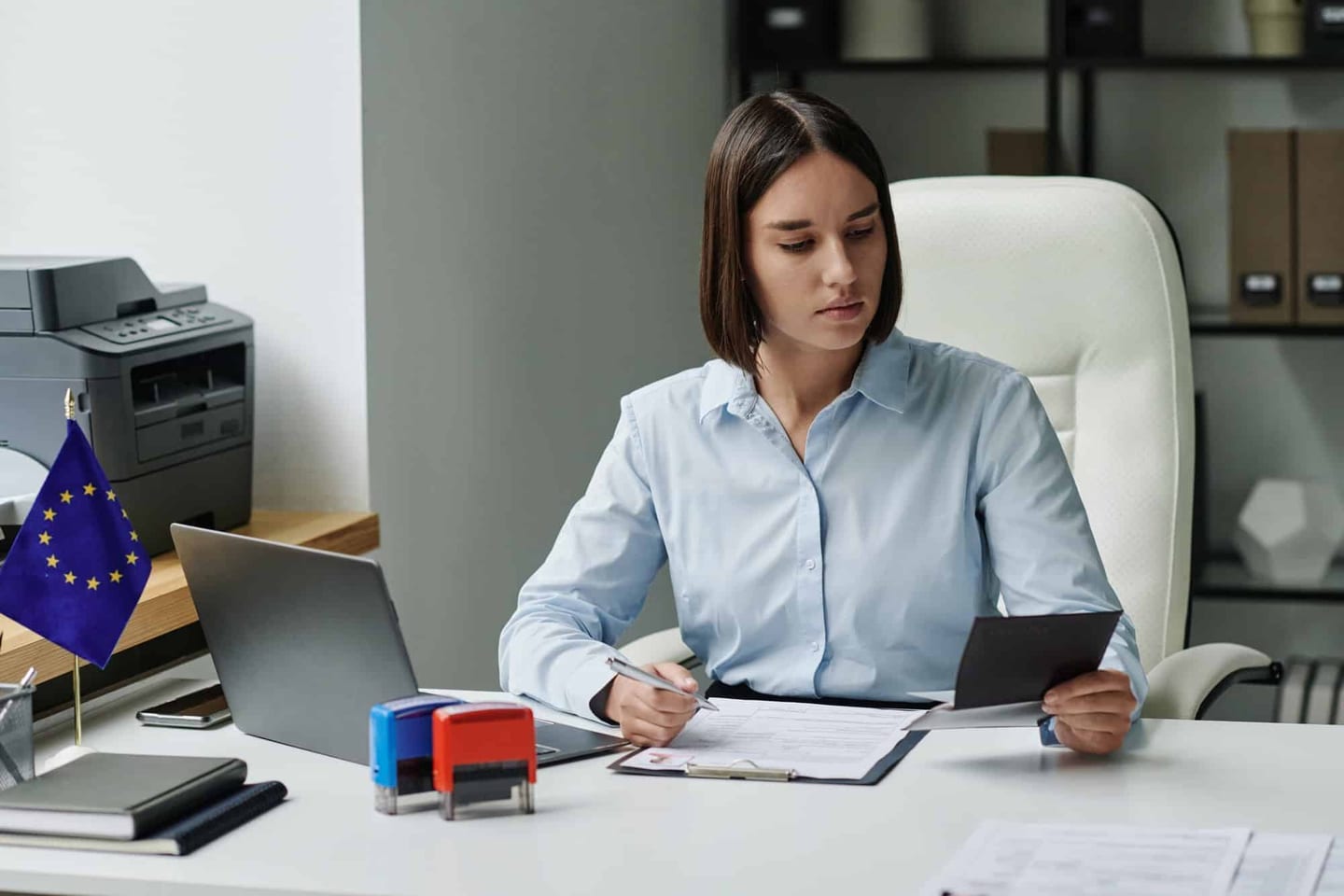 Person filling in official forms at a desk