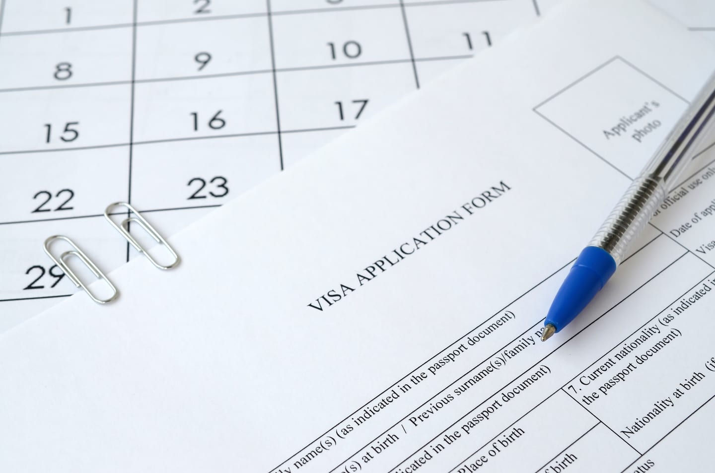 Visa application form with a pen and a calendar