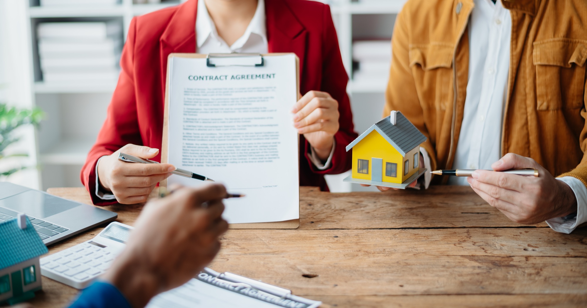 Buying a home or insurance deal, an insurance agent pointing a pen to those interested in renting