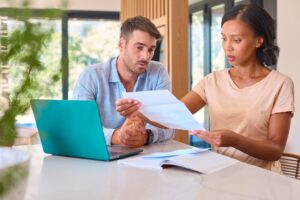 Multi-Racial Couple At Home Worried About Debt Bills And Rising Cost Of Living