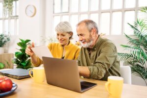 Senior couple managing finances and smiling at home